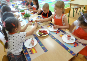Dzieci nakładają serek do wafelków.